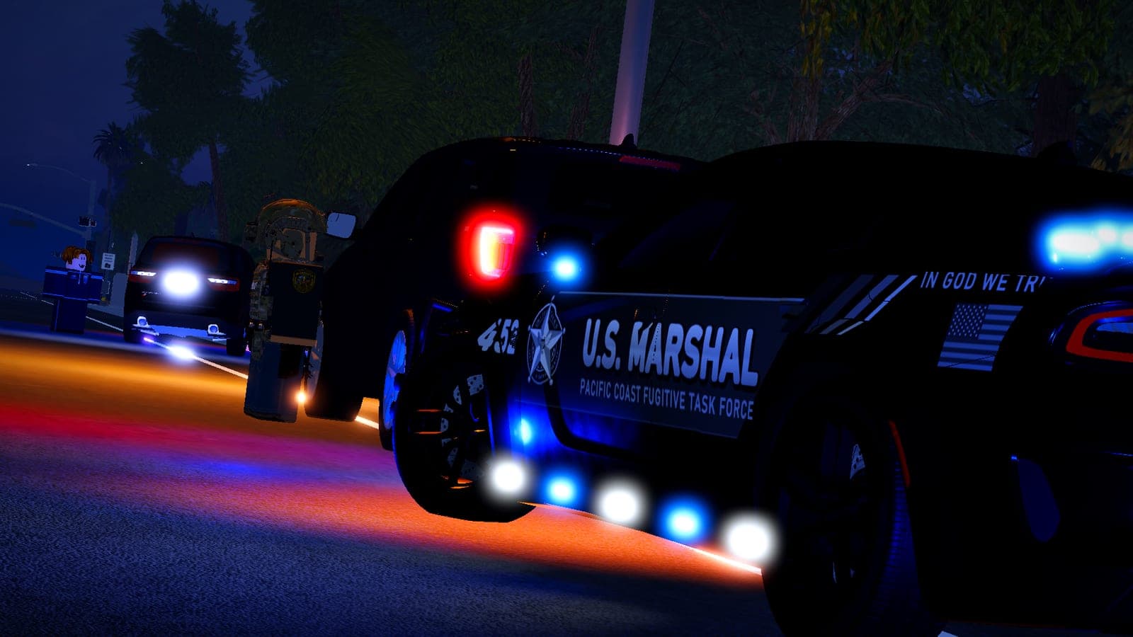 A U.S. Marshal Charger with its lights on during a night stop